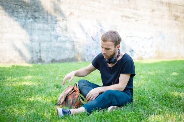 Hipster modern gaya pirang mendengarkan musik di taman — Stok Foto