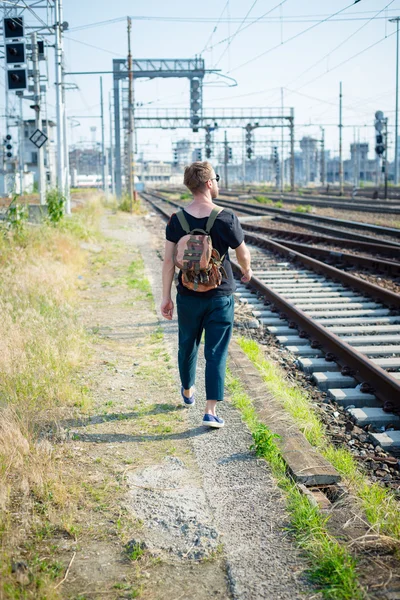 Hipster modern stylish blonde man on rails — Stock Photo, Image