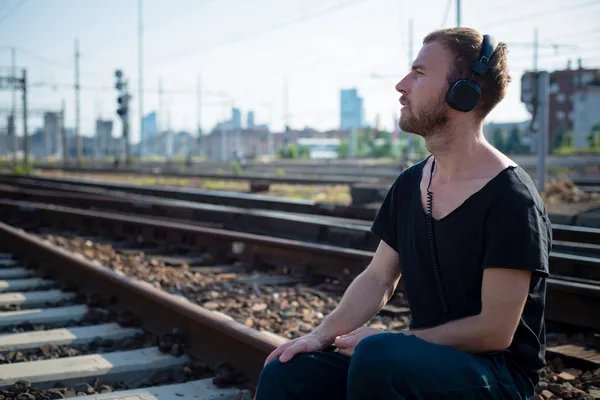 Hipster moderne stijlvolle blonde mens op rails — Stockfoto