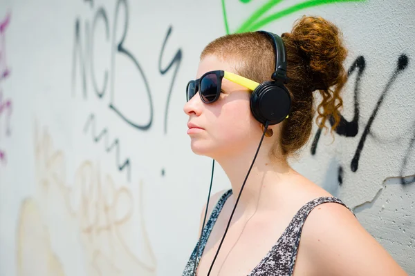 Mooie stijlvolle moderne jonge vrouw luisteren naar muziek — Stockfoto