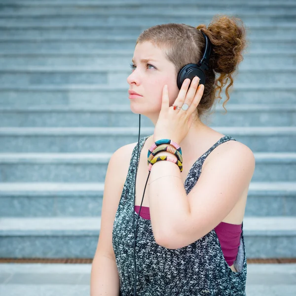 Mooie stijlvolle moderne jonge vrouw luisteren naar muziek — Stockfoto