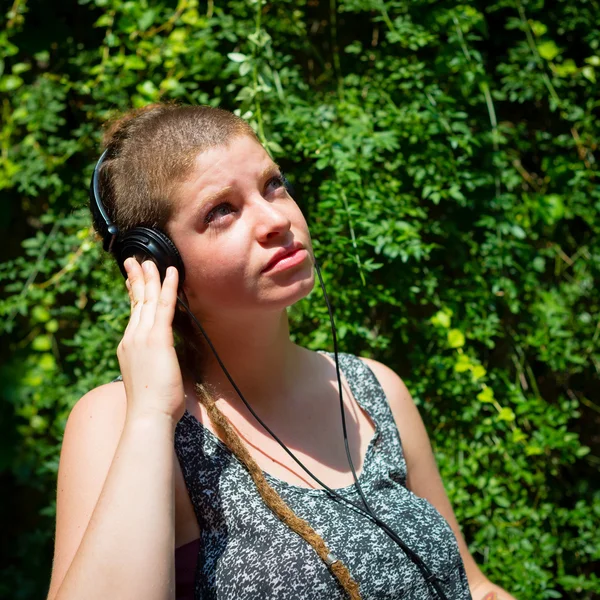 Mooie stijlvolle moderne jonge vrouw luisteren naar muziek — Stockfoto