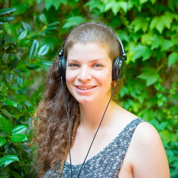 Красивая стильная современная молодая женщина, слушающая музыку — стоковое фото