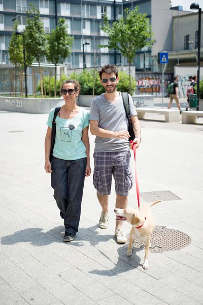 Paar geht mit Hund auf der Straße spazieren — Stockfoto