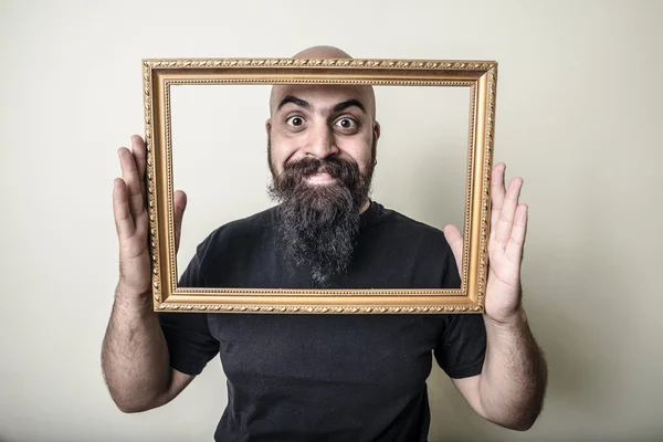 Hombre barbudo divertido con marco de oro — Foto de Stock