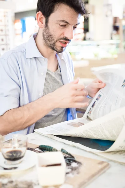 Mann an der Bar liest Zeitung — Stockfoto