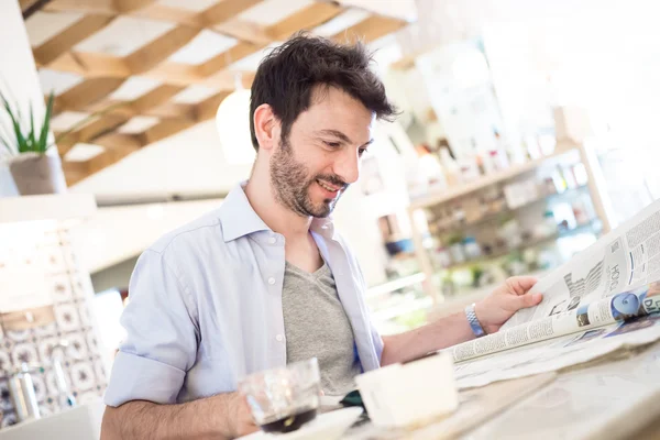 Man aan de balie krant lezen — Stockfoto