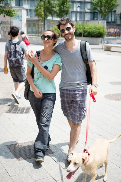 Couple with dog walking in the street — Stock Photo, Image