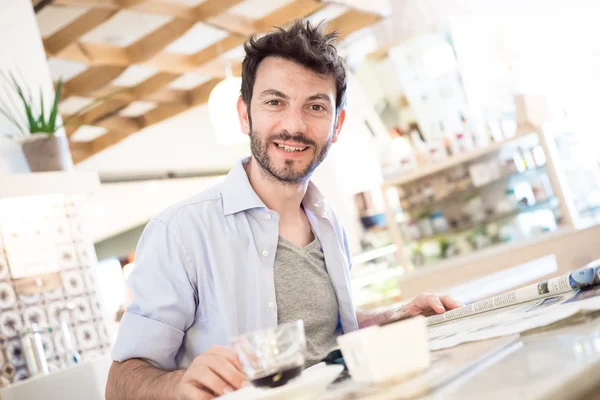 Man at the bar reading newspaper — Stock Photo, Image