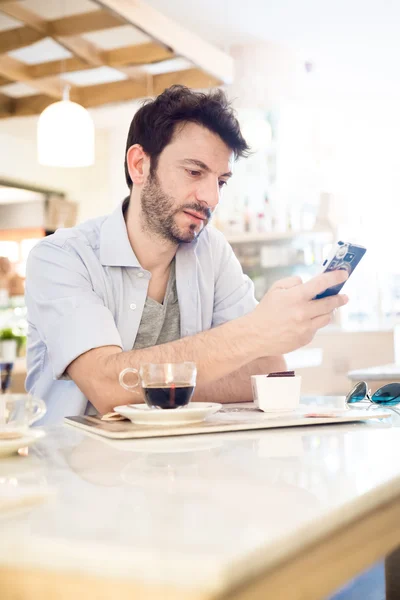 Muž v baru na telefonu — Stock fotografie