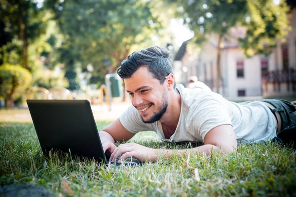 Joven hombre con estilo utilizando portátil — Foto de Stock