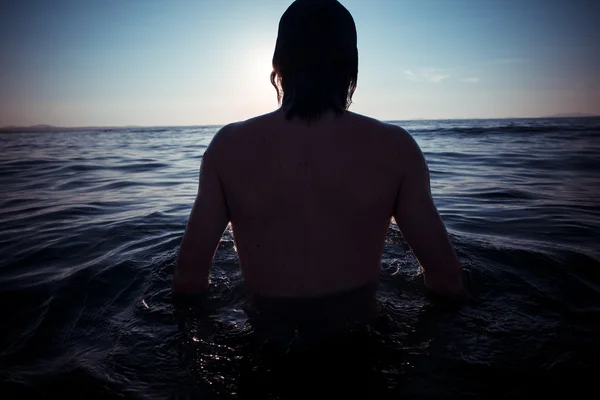 Człowiek powrót do morza na zachód słońca — Zdjęcie stockowe