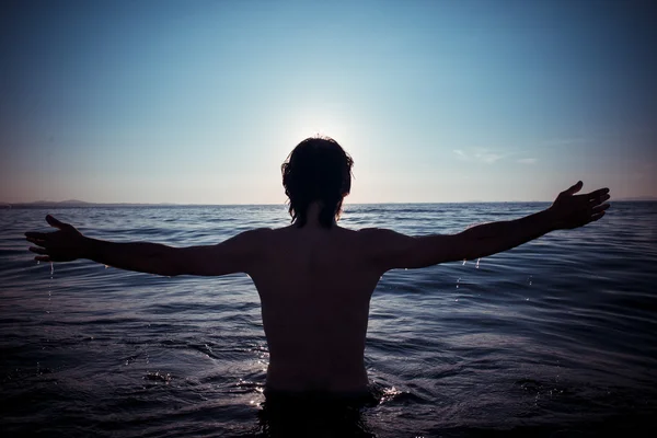 Hombre de vuelta al mar al atardecer —  Fotos de Stock