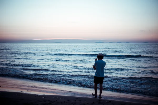 Людина повертається до моря на заході сонця — стокове фото