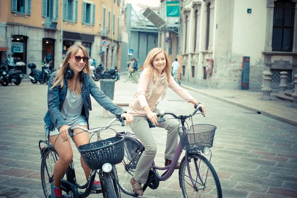 Zwei schöne blonde Frauen auf dem Fahrrad einkaufen — Stockfoto