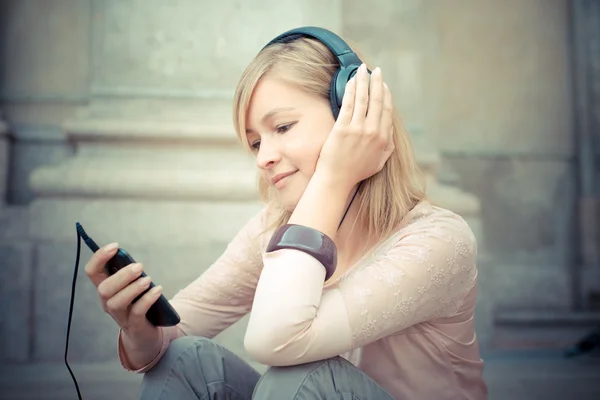 Schöne blonde Frau hört Musik — Stockfoto