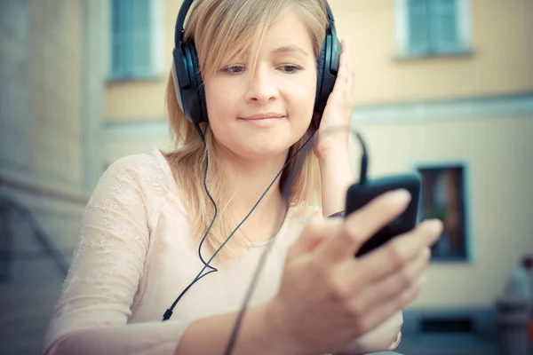 Mooie blonde vrouw luisteren naar muziek — Stockfoto