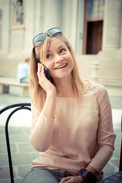 Schöne blonde Frau am Telefon an der Bar — Stockfoto