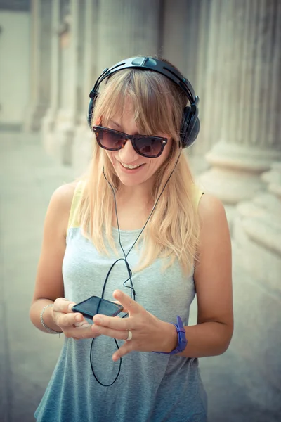 Schöne blonde Frau hört Musik — Stockfoto