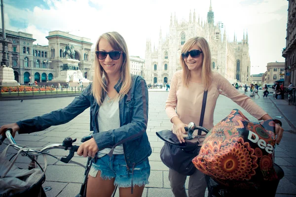 Two beautiful blonde women shopping on bike — Stock Photo, Image