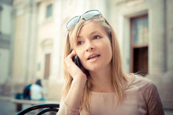 Mooie blonde vrouw op de telefoon in de bar — Stockfoto