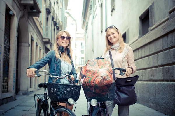 Zwei schöne blonde Frauen auf dem Fahrrad einkaufen — Stockfoto