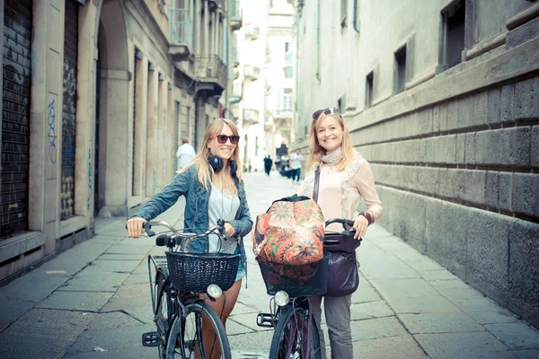 Две красивые блондинки за покупками на велосипеде — стоковое фото