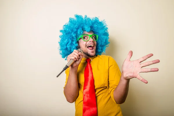 Verrückt lustiger junger Mann mit blauer Perücke — Stockfoto