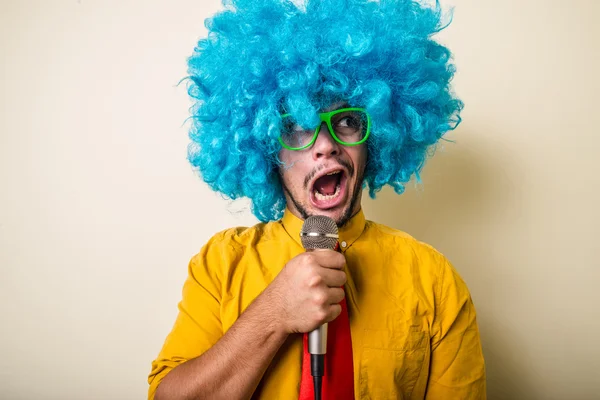 Verrückt lustiger junger Mann mit blauer Perücke — Stockfoto