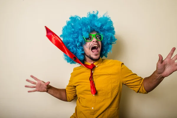 Сумасшедший смешной молодой человек в голубом парике — стоковое фото