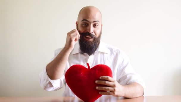Crazy funny bearded man eating heart and falling in love — Stock Video