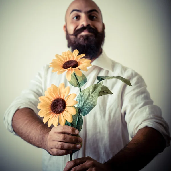 Long beard and mustache man giving flowers — Stock Photo, Image