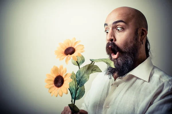 Long beard and mustache man giving flowers — Stock Photo, Image