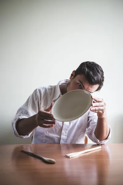 Jovem homem elegante com camisa branca comendo em refeições — Fotografia de Stock