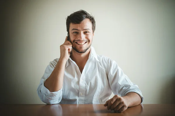 Молодий стильний чоловік з білою сорочкою на телефоні — стокове фото