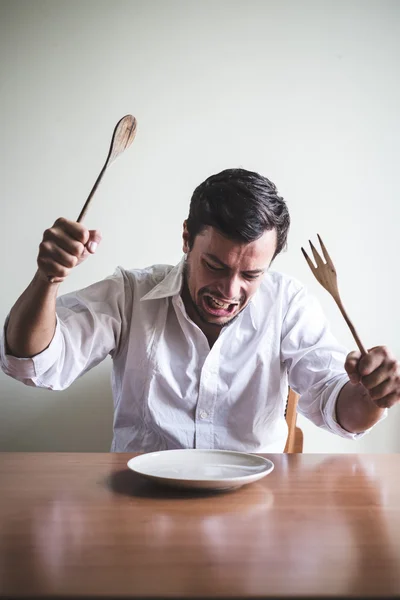 Joven elegante hombre con camisa blanca comiendo en las comidas —  Fotos de Stock