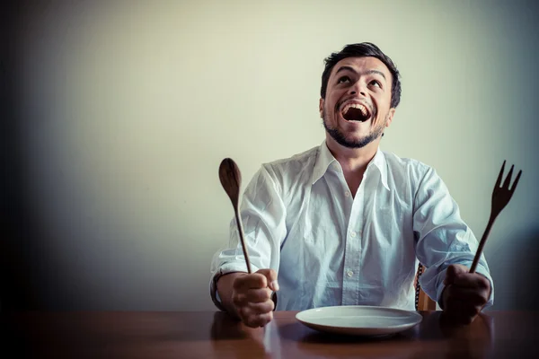 Jovem homem elegante com camisa branca comendo em refeições — Fotografia de Stock
