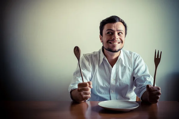 Tânăr om elegant cu cămașă albă care mănâncă în timpul mesei — Fotografie, imagine de stoc