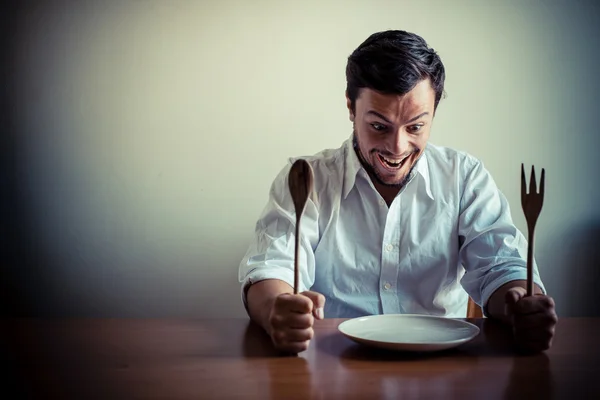 Joven elegante hombre con camisa blanca comiendo en las comidas —  Fotos de Stock