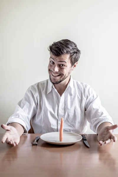 Stilvoller junger Mann mit weißem Hemd, der Möhren isst — Stockfoto