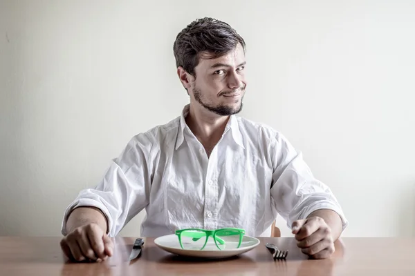 Stijlvolle jongeman met wit overhemd eten groene bril — Stockfoto