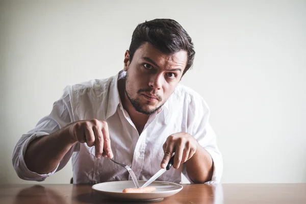 Young stylish man with white shirt eating carrot — Stock Photo, Image