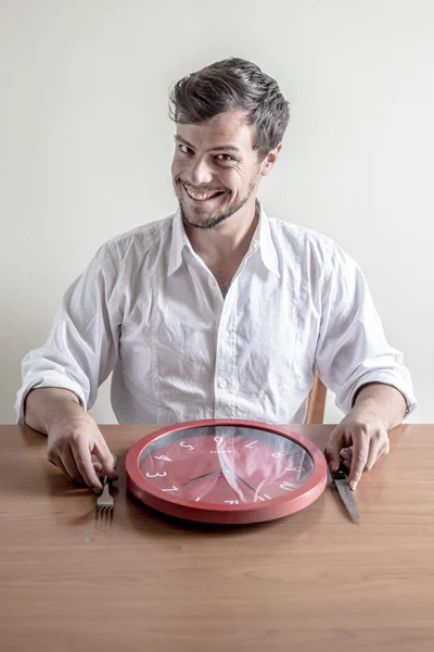 Giovane uomo elegante con camicia bianca mangiare orologio rosso — Foto Stock