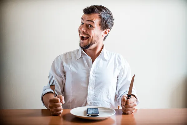 Молодой стильный мужчина в белой рубашке и телефоне на блюде — стоковое фото