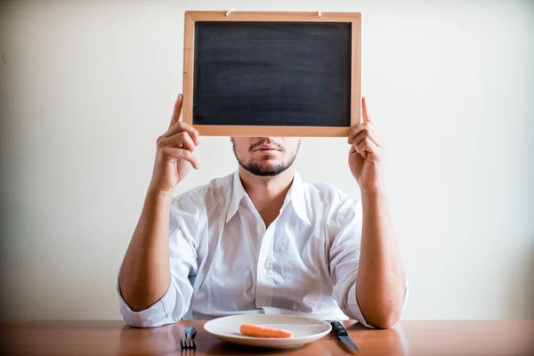 Young stylish man with white shirt holding blackboard — Stock Photo, Image