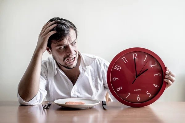 Jeune homme élégant avec chemise blanche tenant horloge rouge — Photo