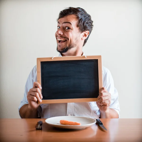 Young stylish man with white shirt holding blackboard — Stock Photo, Image