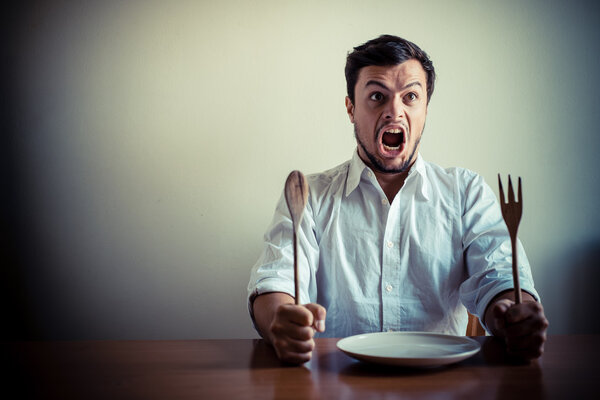 young stylish man with white shirt eating in mealtimes