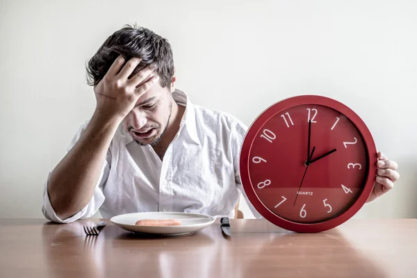 Young stylish man with white shirt holding red clock — Stock Photo, Image