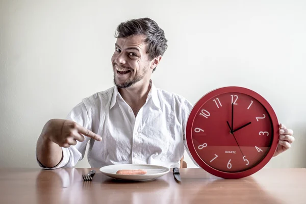 Young stylish man with white shirt holding red clock — Stock Photo, Image